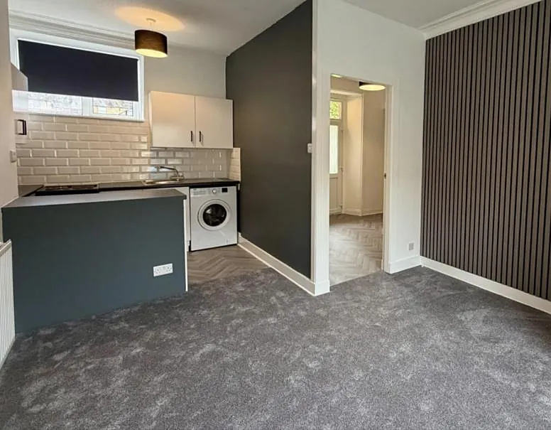 After: the same flat refurbished, with a slatted feature wall, new kitchen and fresh carpet