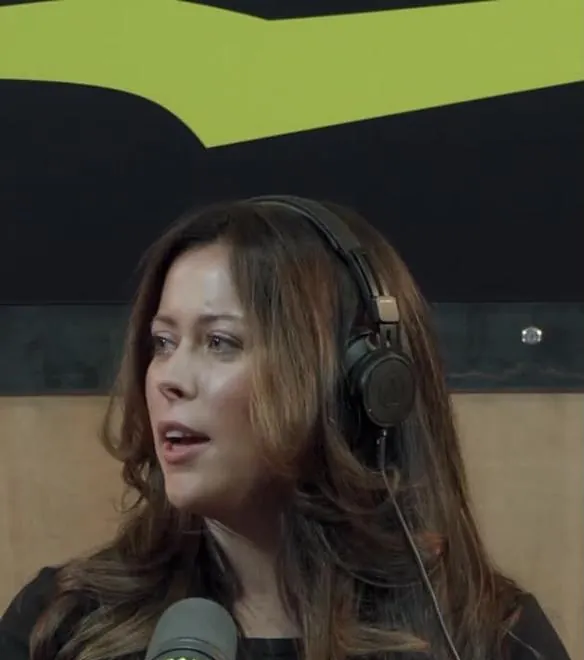 Emma wearing headphones at a podcast microphone