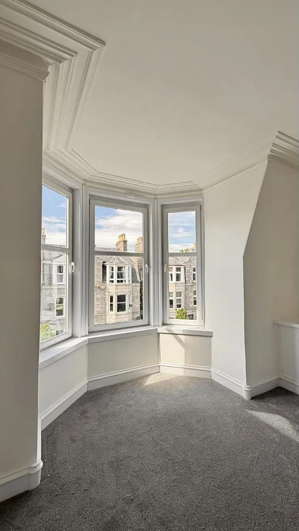 Granite tenements seen through a bright bay window in Aberdeen